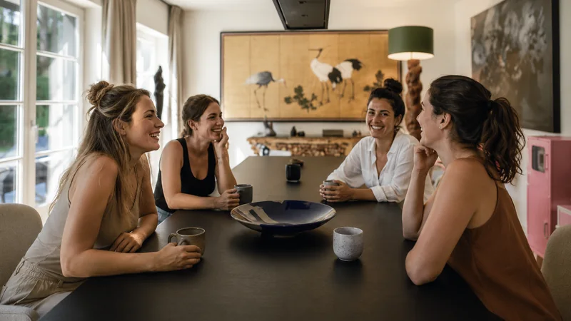 Quatre femmes discutant ensemble à une table dans un environnement calme